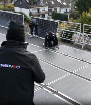 Teamfoto bei der Arbeit, eine Solaranlage zu platzieren