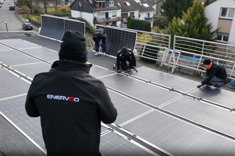 Teamfoto bei der Arbeit, eine Solaranlage zu platzieren
